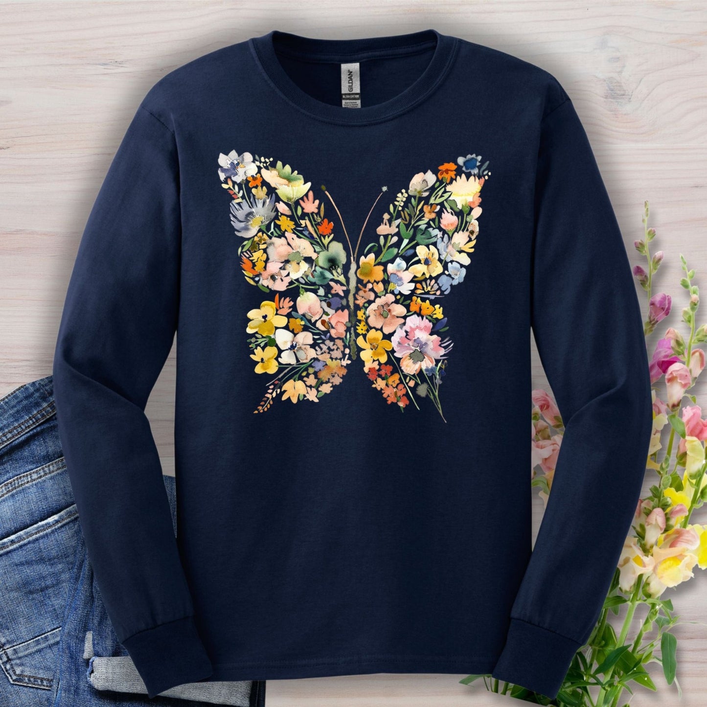 Navy long sleeve tee with a watercolor floral butterfly design, made from 50/50 cotton-poly fabric.