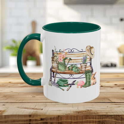 White ceramic mug with a deep green handle and interior, featuring a watercolor garden bench design.