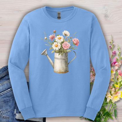 Carolina Blue long-sleeve tee with a vintage watering can and botanical illustration of daisies, peonies, and cosmos.