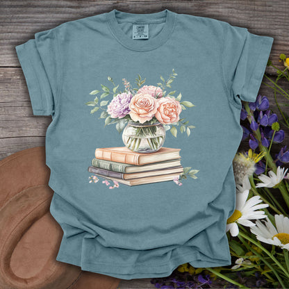 Ice Blue S t-shirt with a watercolor bouquet of pastel roses in a vase on vintage books.