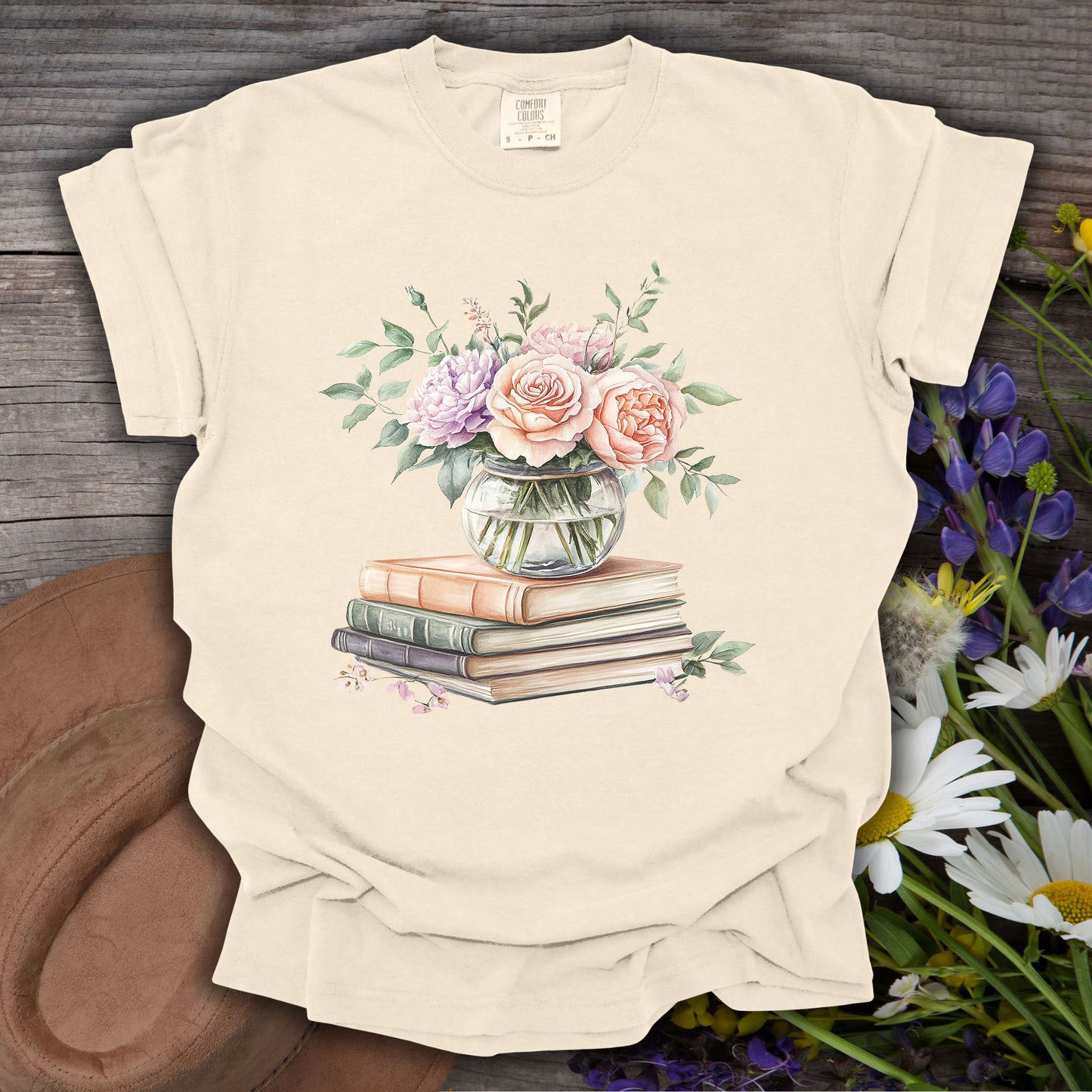 Ivory S t-shirt with a watercolor bouquet in a glass vase on vintage books.