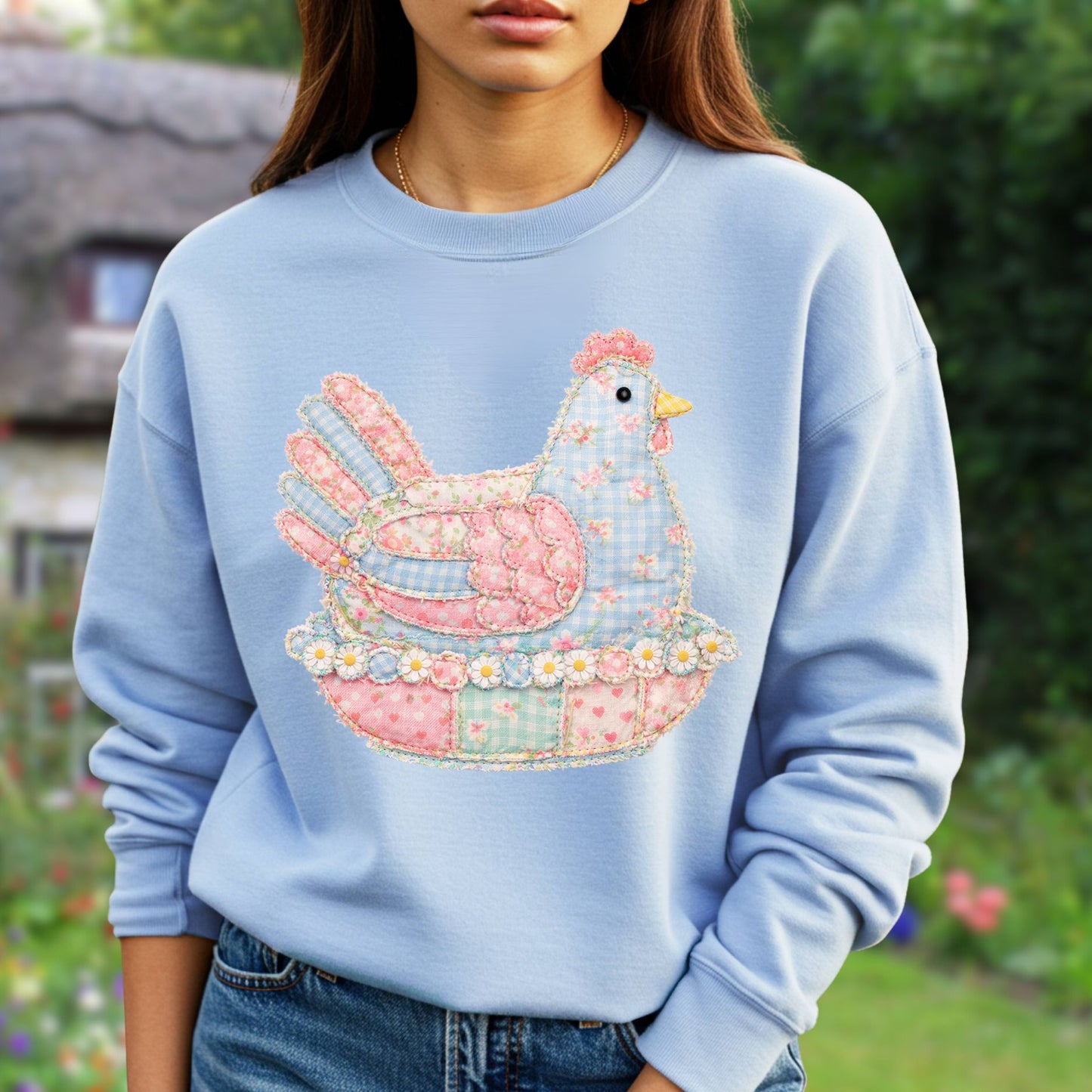 Light blue sweatshirt with a faux patchwork hen graphic in pastel pink, blue, and green floral and gingham patterns.