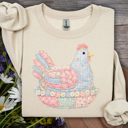 Sand unisex sweatshirt with a pastel faux patchwork hen design, featuring blue, pink, and floral patterns.