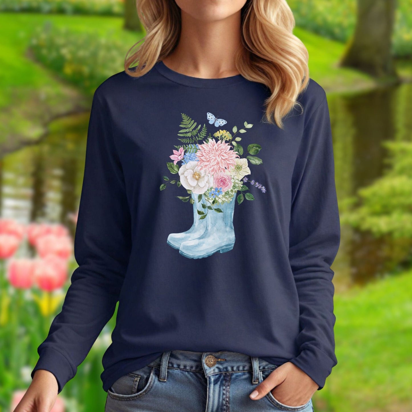 Navy long sleeve tee with a watercolor rain boot overflowing with pink, white, and purple flowers.