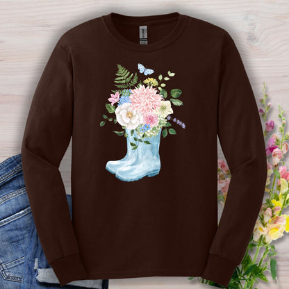 Dark Chocolate long-sleeve tee with a watercolor light blue rain boot overflowing with pink, white, and purple flowers.