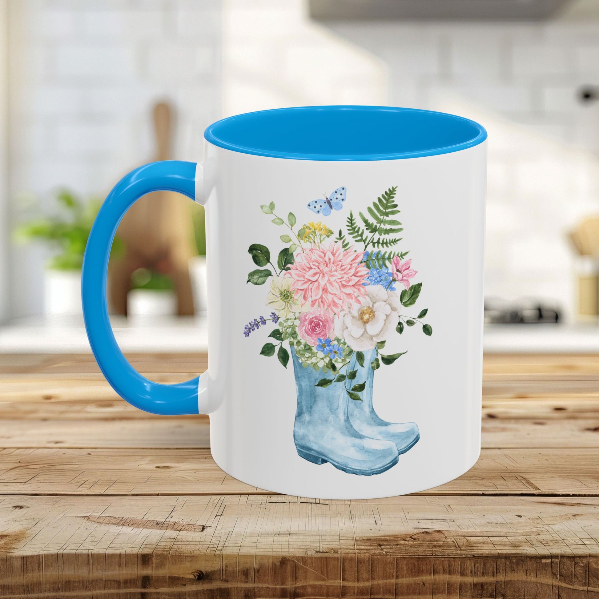 White ceramic mug with blue handle and interior, featuring a watercolor rain boot with a floral bouquet.