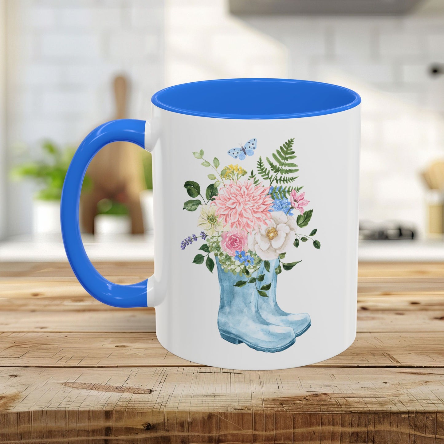 White ceramic mug with blue handle and interior, featuring a watercolor rain boot with a floral bouquet.
