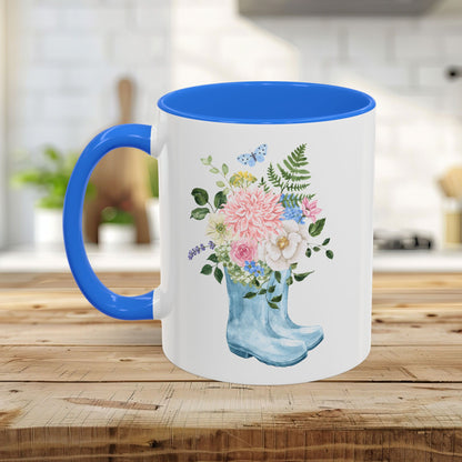 White ceramic mug with blue handle and interior, featuring a watercolor rain boot with a floral bouquet.