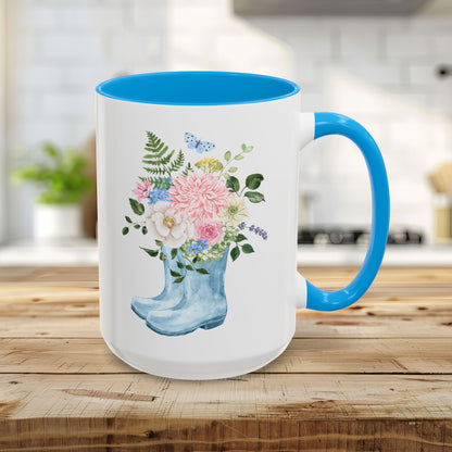 15oz glossy ceramic mug with a light blue handle and interior, featuring a watercolor rain boot with a floral bouquet.