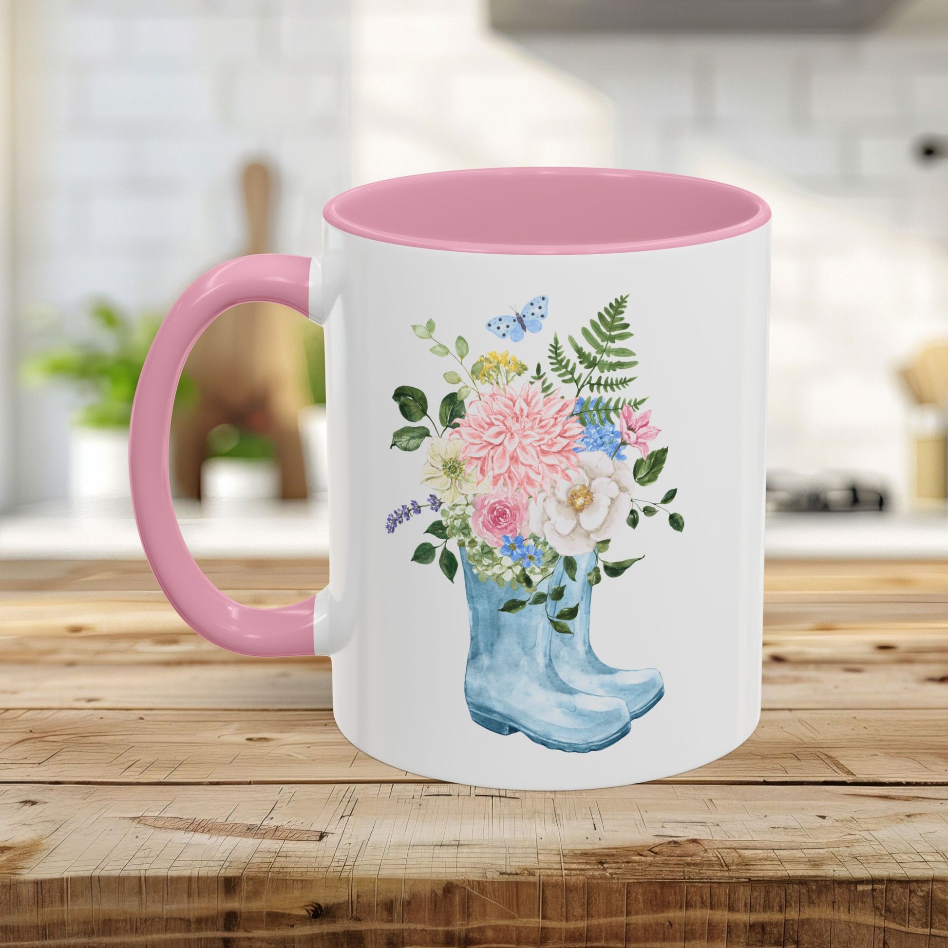 White ceramic mug with pink handle and interior, featuring a watercolor rain boot with a floral bouquet.
