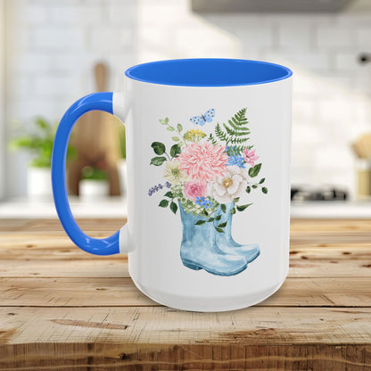 White ceramic mug with blue handle and interior, featuring a watercolor rain boot with a floral bouquet.