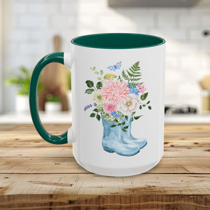 White ceramic mug with a green handle and interior, featuring a watercolor rain boot filled with flowers.