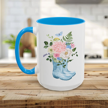 White ceramic mug with blue handle and interior, featuring a watercolor rain boot with a floral bouquet.