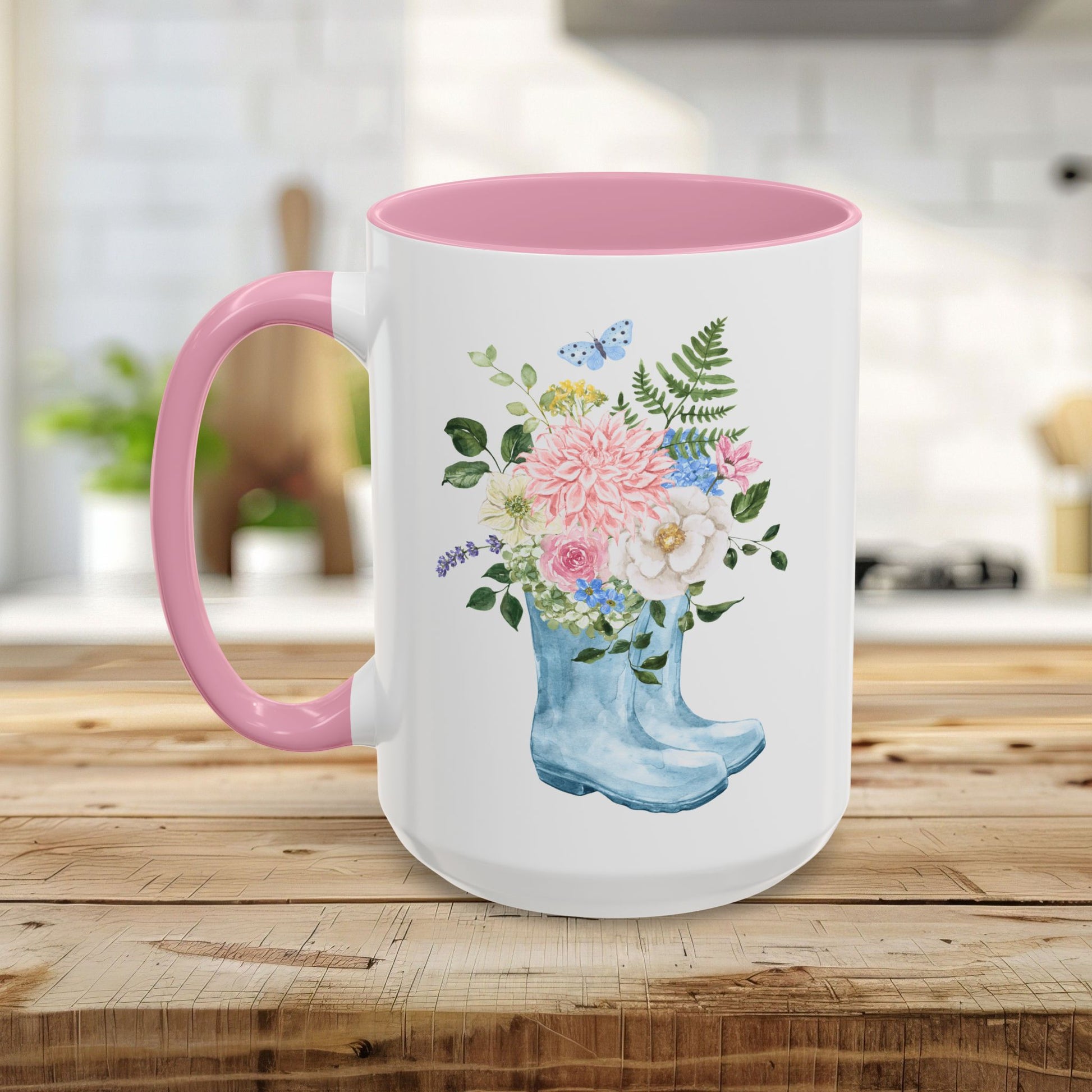 White ceramic mug with pink handle and interior, featuring a watercolor rain boot with a floral bouquet.
