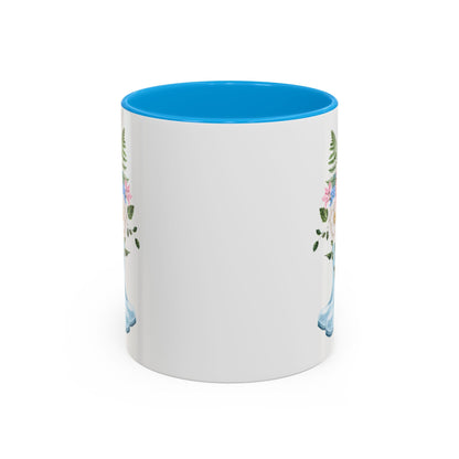 White ceramic mug with blue interior and handle, featuring a watercolor rain boot and floral bouquet design.