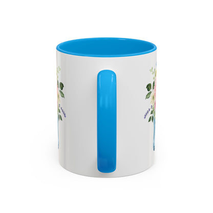 White ceramic mug with blue handle and interior, featuring a watercolor rain boot and floral bouquet design.