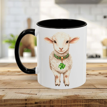 White ceramic mug with black handle and interior, featuring a watercolor lamb with a green clover pendant.