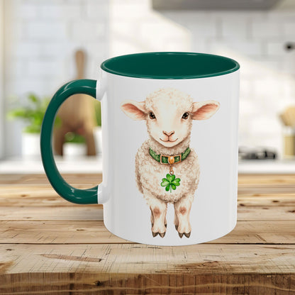 White ceramic mug with a green handle and interior, featuring a watercolor lamb wearing a clover pendant.