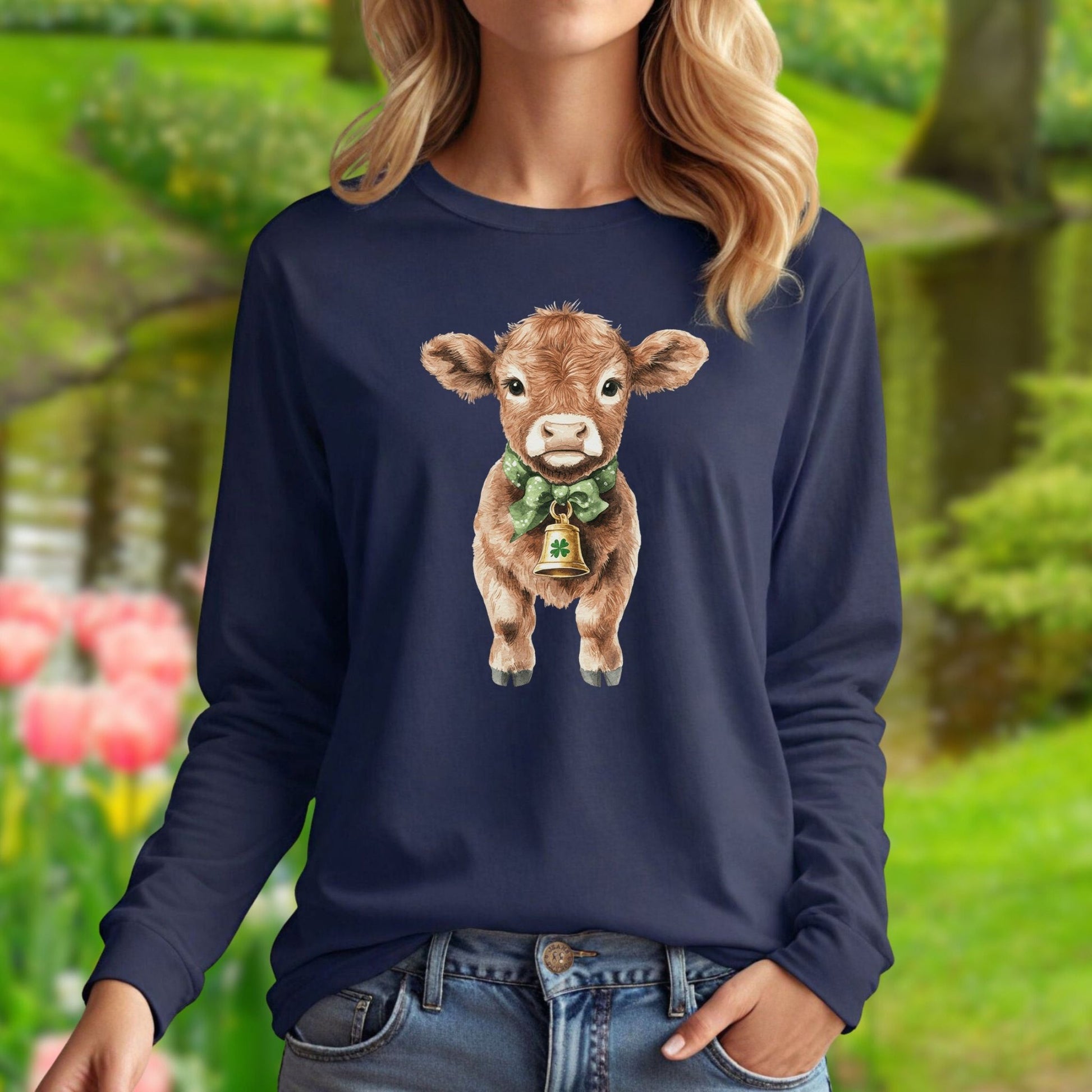 Navy long sleeve tee with a watercolor baby Highland cow wearing a green bow and clover bell.