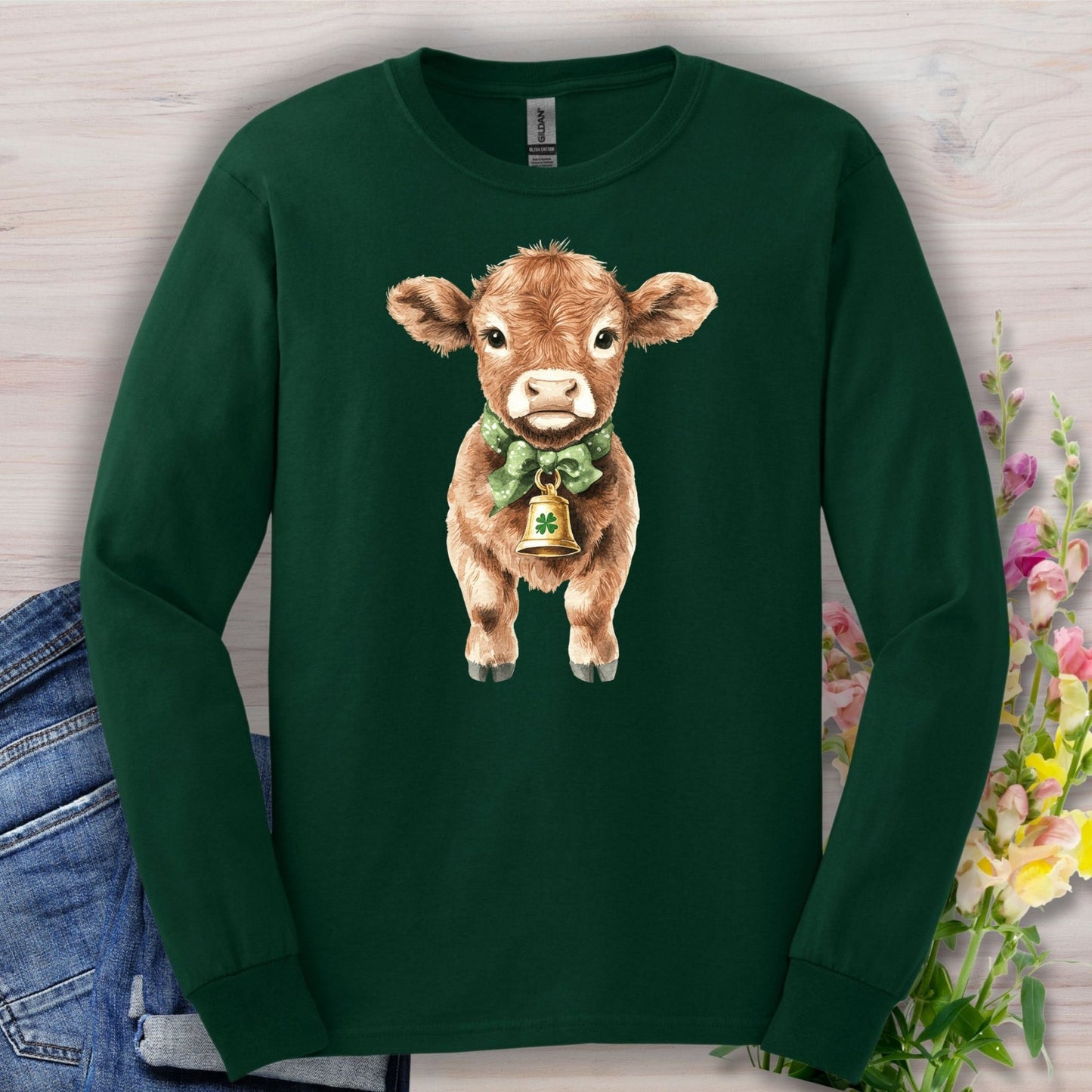 Forest Green long sleeve tee with a watercolor baby Highland cow wearing a clover bow tie and bell.