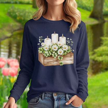 Navy long sleeve tee with a watercolor wooden planter, white daisies, candles, and four-leaf clovers.