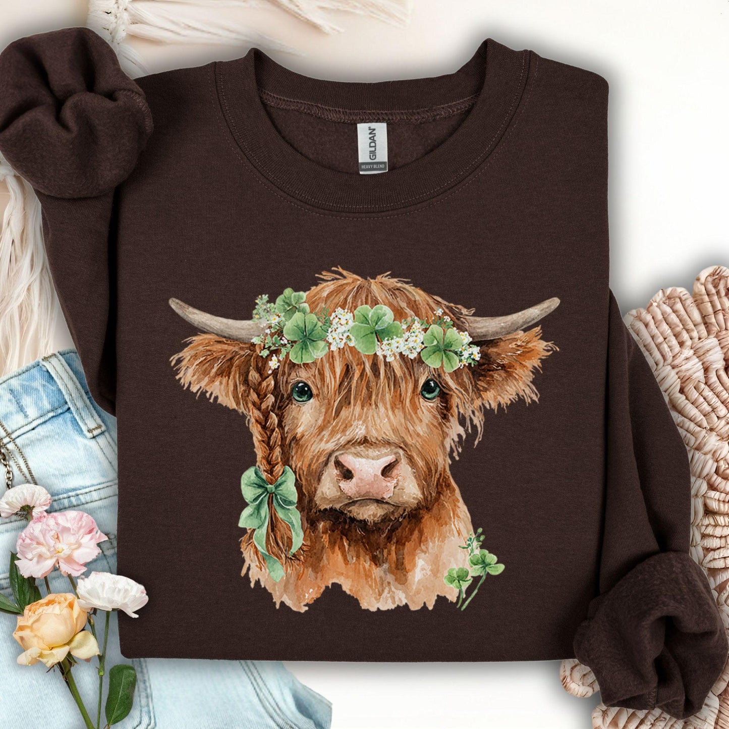 Dark chocolate sweatshirt with watercolor Highland cow wearing clover garland and green bow.