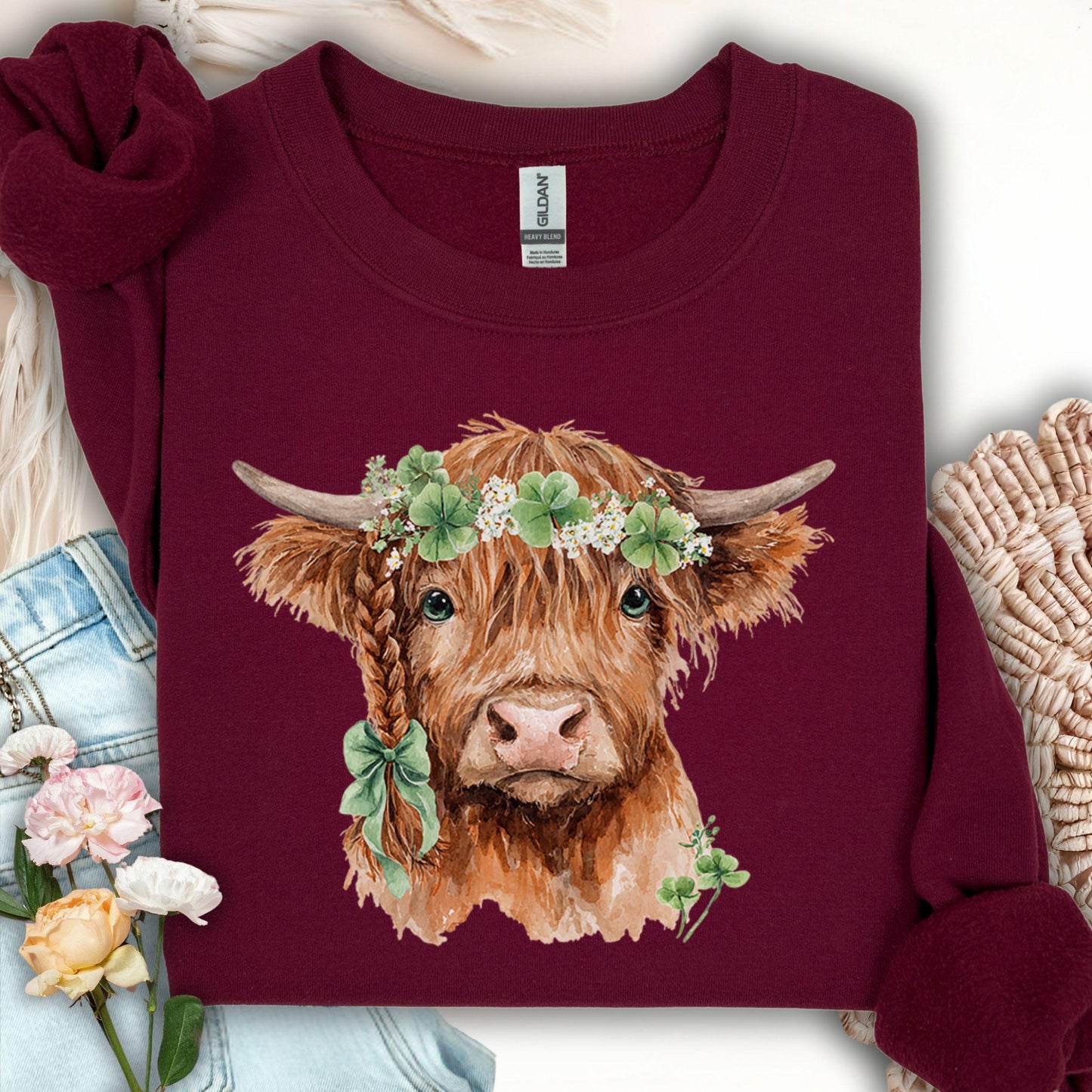 Maroon sweatshirt with watercolor Highland cow in clover garland and bow, size S.