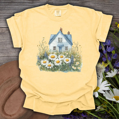 Butter yellow garment-dyed t-shirt with a blue cottage and wildflower field graphic.