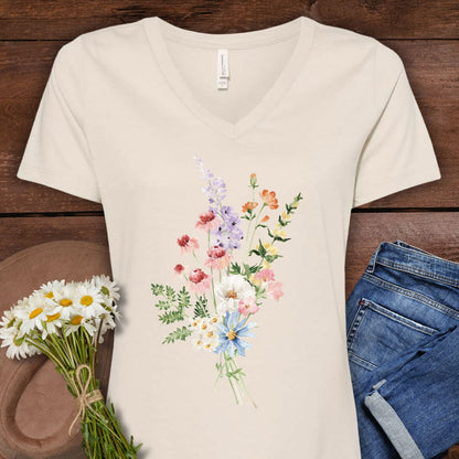 Faded rose v-neck t-shirt with a delicate watercolor wildflower bouquet design, paired with jeans and daisies.