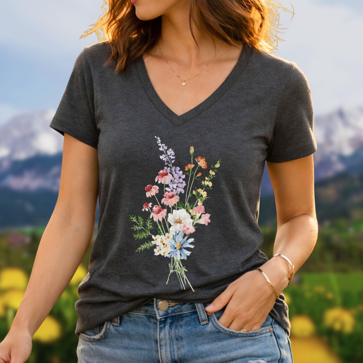 Charcoal gray v-neck t-shirt with a colorful wildflower bouquet illustration, worn by a woman outdoors.
