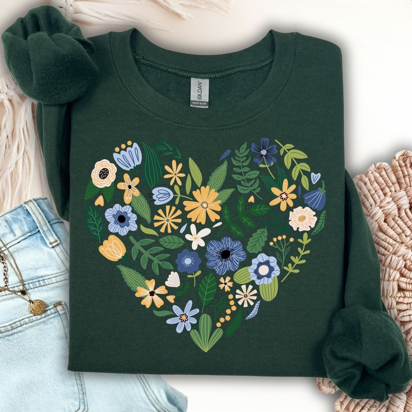 Forest green sweatshirt with a large heart made of blue, yellow, and cream floral designs.