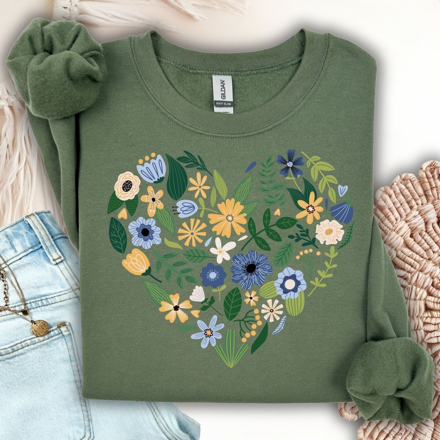 Military green sweatshirt with a heart design made of blue, yellow, and cream floral blooms.