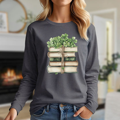 Woman in a charcoal long-sleeve tee with a watercolor stack of books and clovers design.