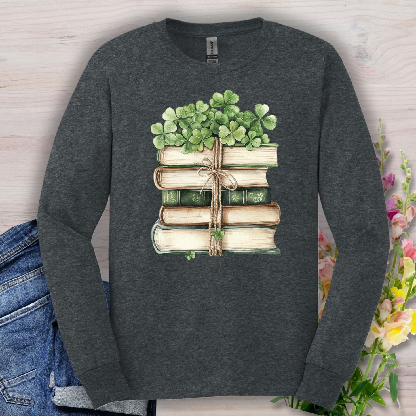 Dark Heather long sleeve tee with a watercolor stack of vintage books and green four-leaf clovers.