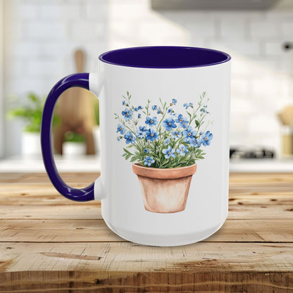 White ceramic mug with blue handle/interior, featuring a watercolor terracotta pot with blue forget-me-nots.