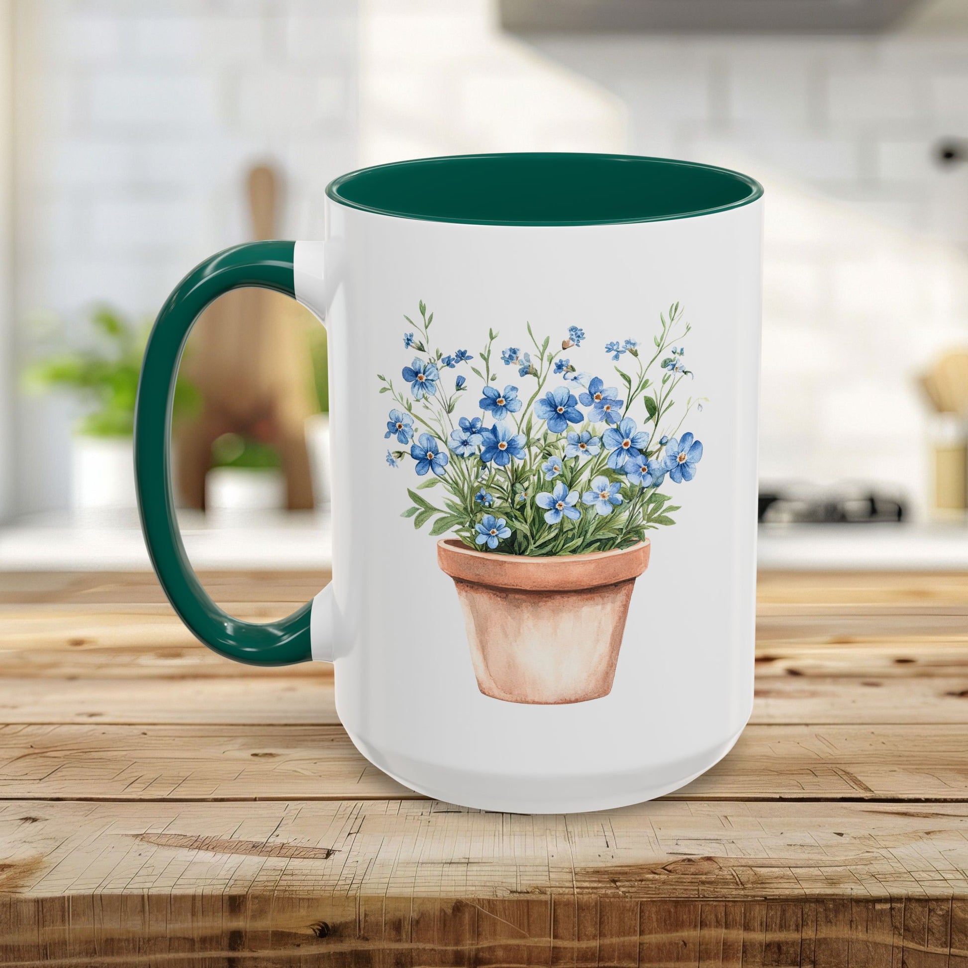 White ceramic mug with green handle and interior, featuring a watercolor terracotta pot with blue forget-me-nots.