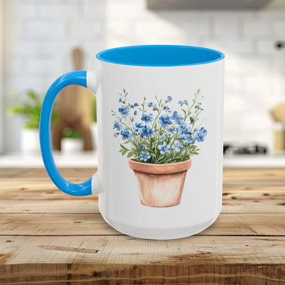 White ceramic mug with a blue handle and interior, featuring a watercolor terracotta pot with blue forget-me-nots.
