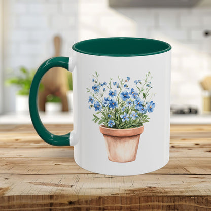 White ceramic mug with green handle and interior, featuring a watercolor terracotta pot with blue forget-me-nots.