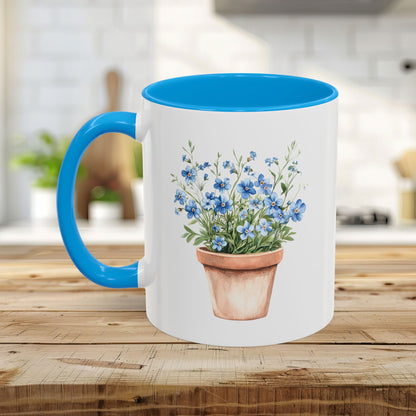 White ceramic mug with a blue handle and interior, featuring a watercolor terracotta pot with blue forget-me-nots.