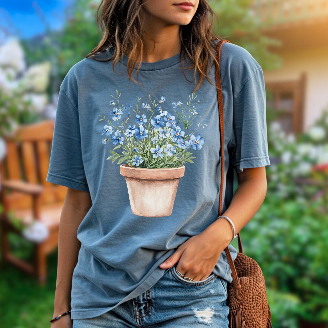 Garment-dyed blue t-shirt with a watercolor terracotta pot of blue forget-me-nots.