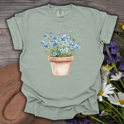 Garment-dyed Bay green cotton t-shirt with a watercolor terracotta pot of blue forget-me-nots.