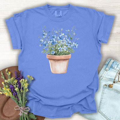 Periwinkle S cotton t-shirt with a watercolor terracotta pot of blue forget-me-nots.