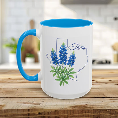 White ceramic mug with blue interior and handle, featuring a bluebonnet illustration inside a Texas outline.