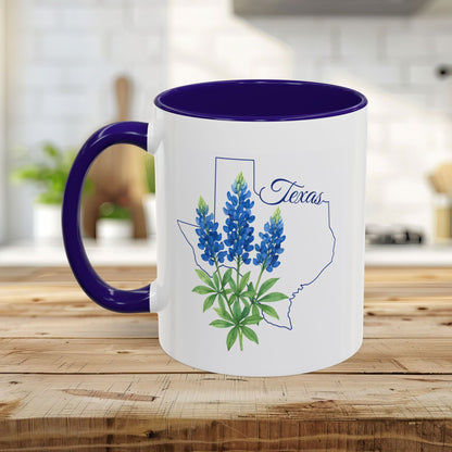 White ceramic mug with bluebonnet flowers inside a Texas outline, purple interior and handle.