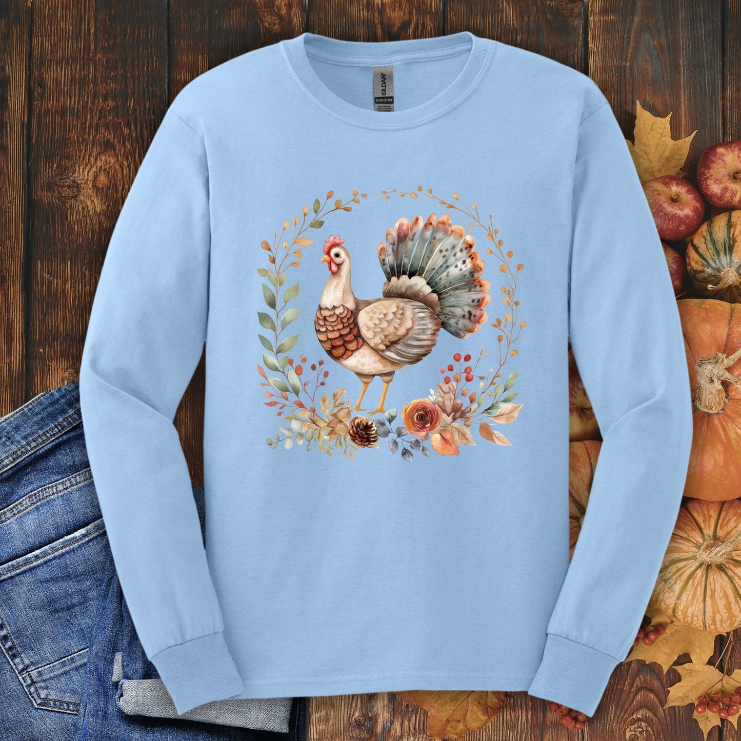 Light blue long sleeve tee with a watercolor Thanksgiving turkey and autumn foliage design.