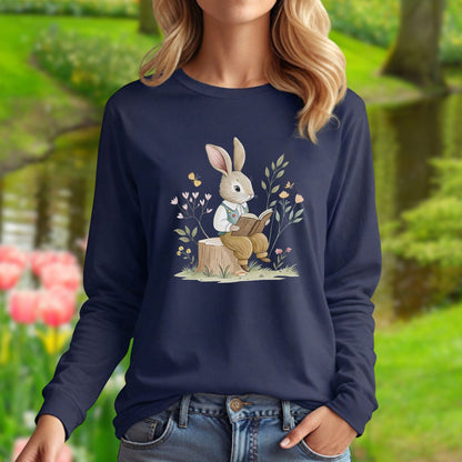 Navy long-sleeve tee with a whimsical rabbit reading on a tree stump, surrounded by spring botanicals.