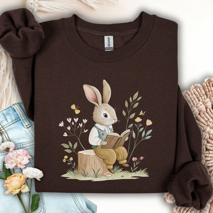 Dark Chocolate sweatshirt with a bookish bunny in a waistcoat reading on a tree stump, surrounded by spring flowers.