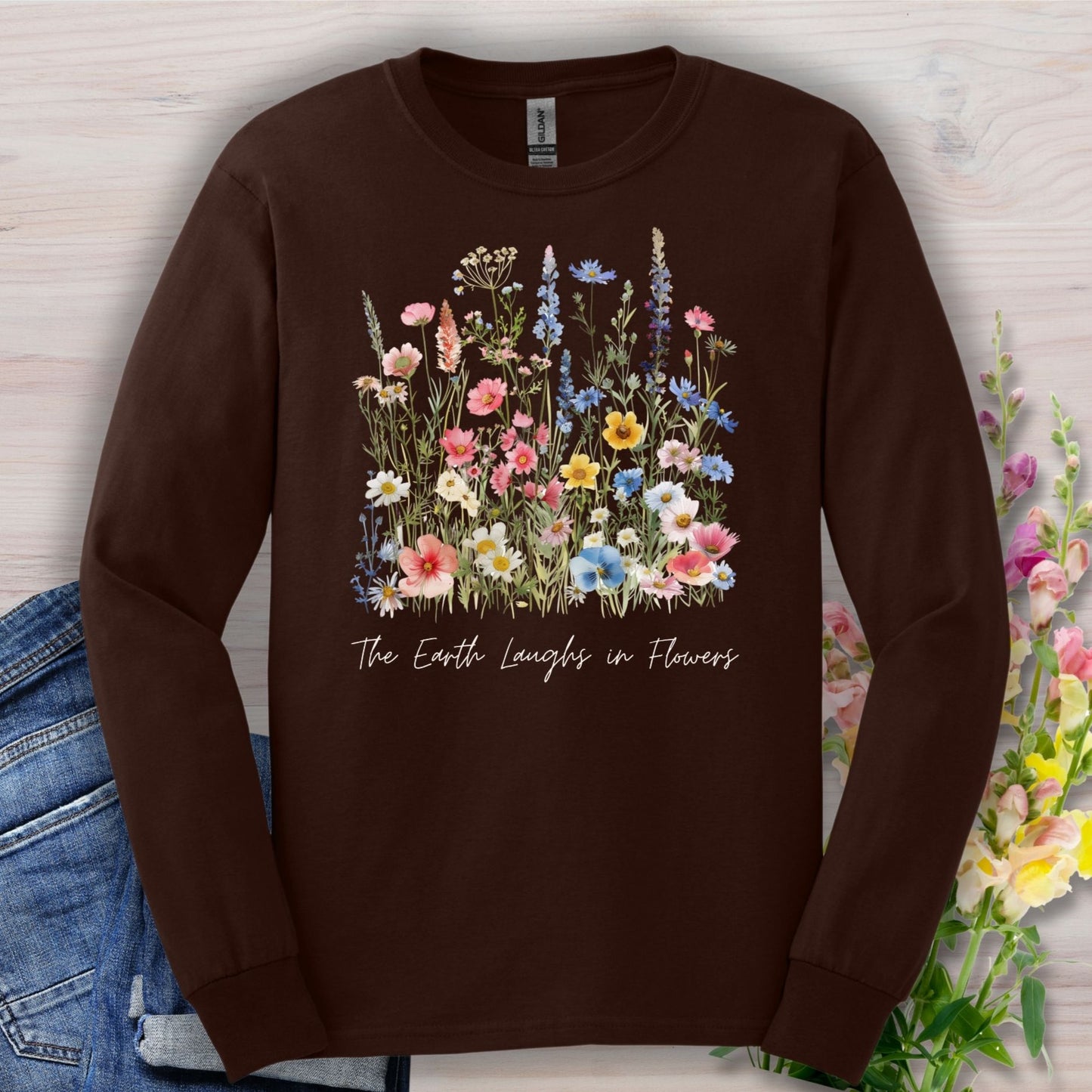 Dark Chocolate long-sleeve tee with watercolor wildflowers and "The Earth Laughs in Flowers" text.