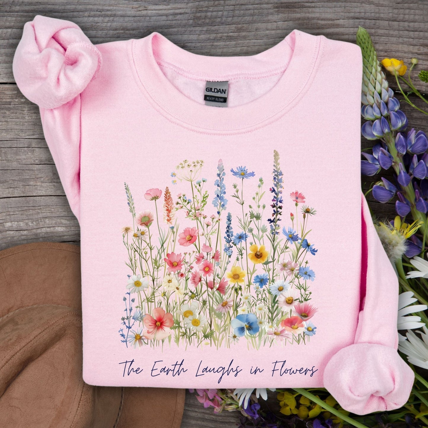 Light pink crewneck sweatshirt with a colorful wildflower bouquet and "The Earth Laughs in Flowers" text.