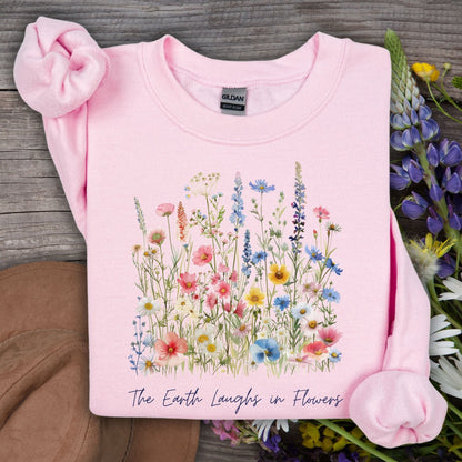 Light pink crewneck sweatshirt with a colorful wildflower bouquet and "The Earth Laughs in Flowers" text.